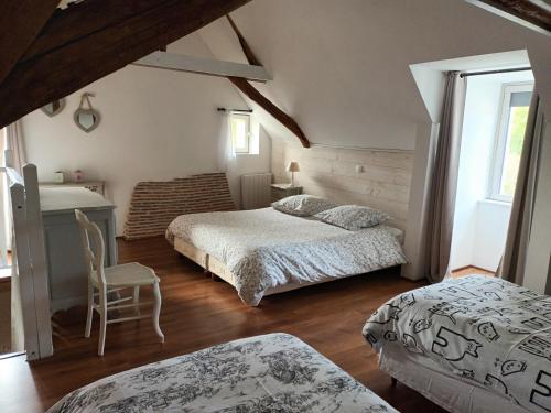 Les HermitesAu bout du monde 1的一间卧室配有两张床、一张桌子和一把椅子