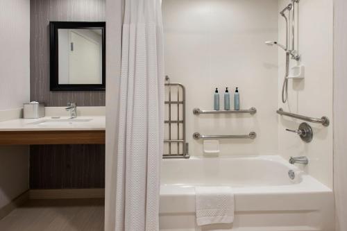 维斯塔宾厄姆顿万怡酒店的白色的浴室设有浴缸和水槽。