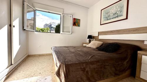 贝尼多姆Bungalow Playa Poniente Benidorm的一间卧室设有一张床和一个大窗户