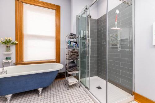 迪比克The Dubuque House - Historic Downtown Location!的带浴缸和玻璃淋浴间的浴室。