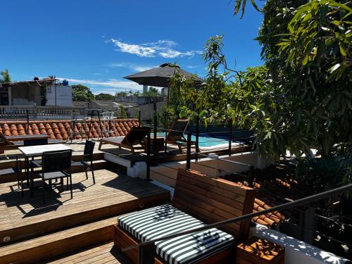 卡塔赫纳Los Patios Hostel的一个带桌椅的甲板和一个游泳池