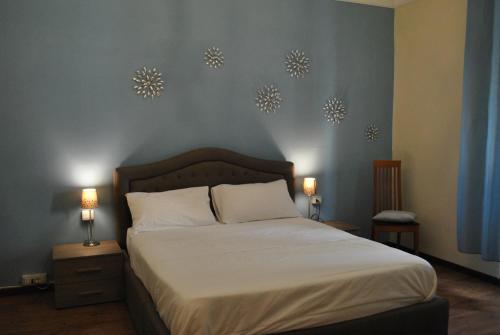 普拉托Appartamento Guido的卧室配有一张床,墙上挂着两盏灯