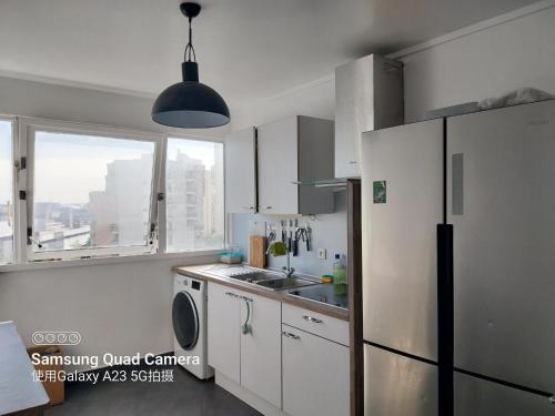 克雷泰伊La chambre de l'appartement的白色的厨房配有冰箱和水槽