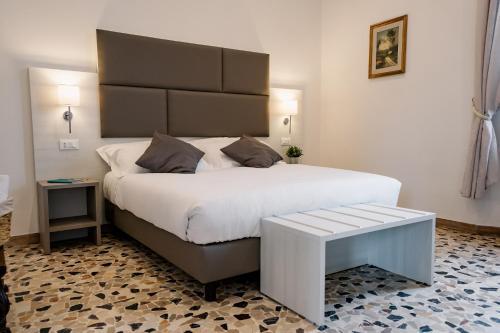 圣彼得罗-泰尔梅堡LaMì Room & Apartment的一间卧室配有一张大床,旁边设有长凳