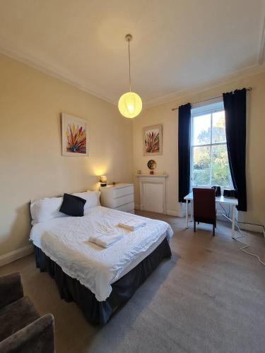 爱丁堡Haymarket Station Rooms的卧室配有床、椅子和窗户。