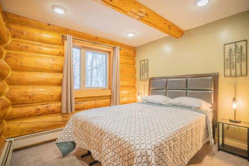 费尔班克斯Tucked Away Timber Lower Suite的卧室配有一张床铺,位于带木墙的房间内