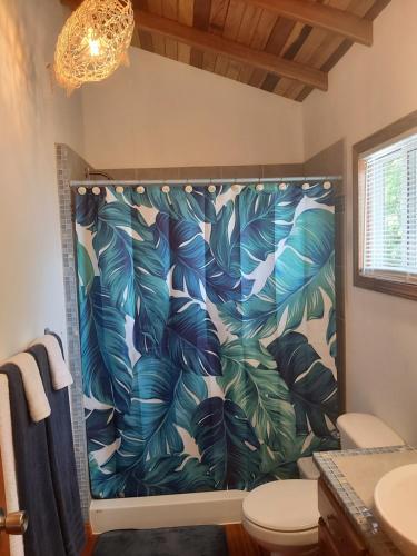 珀拉什奇亚Bella Vita Casitas的浴室配有带热带叶子的浴帘