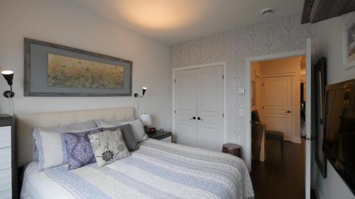 布罗蒙Le 204 Champlain Bromont的一间卧室配有一张带蓝色和灰色枕头的床