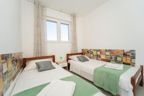 尼亚卢卡SVEMA APARTMAN的一间卧室设有两张床和窗户。