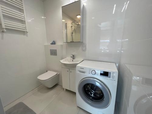 什切青Apartament Słoneczne Szczecin的白色的浴室设有洗衣机和水槽。