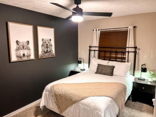 斯诺肖Remodeled Summit Condo at Snowshoe - Modern & Cozy的卧室配有一张墙上有两张照片的床。