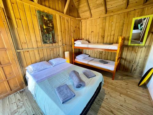 普腊亚罗萨Pousada Lua de Java - Suíte Lombok的小木屋内一间卧室,配有两张床
