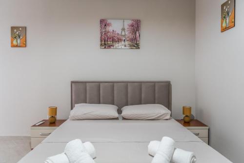 都拉斯Brand New Apartment- Great location Seafront with pool access的一间卧室配有带2条白色毛巾的床