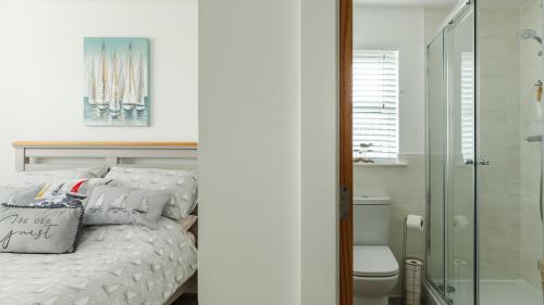 安斯特拉瑟Wee Jules By The Sea的一间卧室设有一张床和一个玻璃淋浴间
