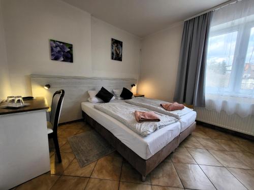 班斯卡-比斯特里察Alcorso Pension的一间卧室配有一张床、一张书桌和一个窗户。