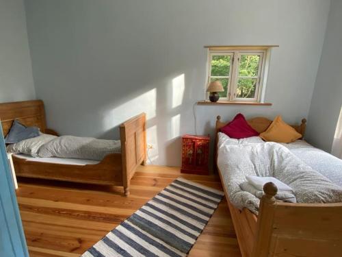 坡瑟利特兹Wohnung in historischem Pfarrhof auf Rügen的一间卧室设有两张床和窗户。