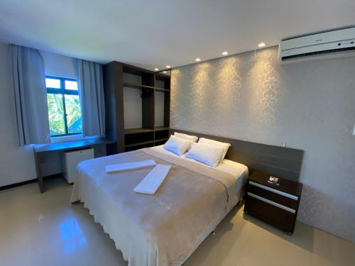 弗洛里亚诺波利斯Spazio Vital Apartments的一间卧室配有一张带两个白色枕头的大床