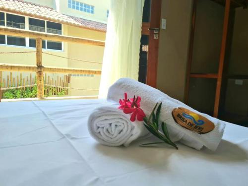 杰里科科拉Deu Praia Pousada的床上挂着一条毛巾和一朵花