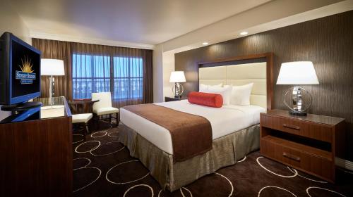 拉斯维加斯Sunset Station Hotel & Casino的酒店客房设有一张大床和一台电视。