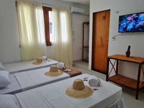 杰里科科拉Deu Praia Pousada的配有2张床的带帽子的房间