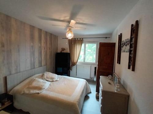 Pauappartement T2 - 4 personnes的一间卧室配有一张床和吊扇
