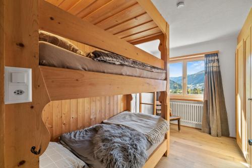 达沃斯A&Y Chalet zum goldenen Hirsch的一间卧室设有两张双层床和一扇窗户。