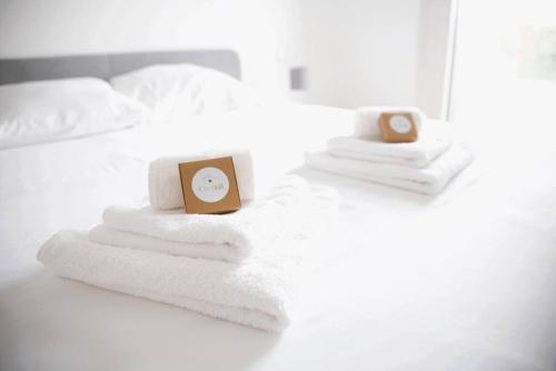 卢森堡Beautiful Stylish 2BR Apartment in Kirchberg的一张带毛巾的床和闹钟