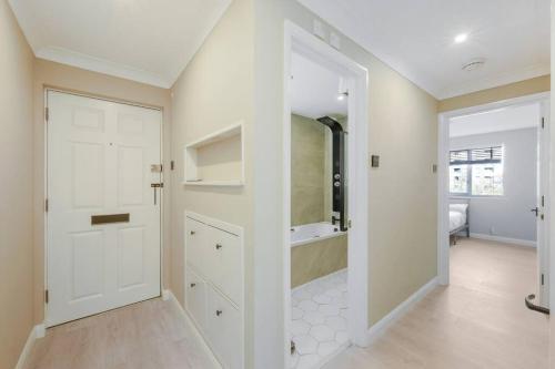 泰晤士河畔金斯顿Luxury Apartment in Kingston的带淋浴的浴室和白色门