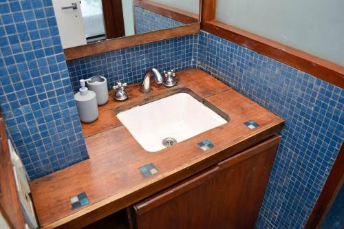 奥利沃斯Libertador 2785 by depptö的浴室配有水槽和蓝色瓷砖墙。