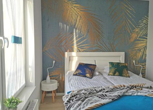 尤斯托尼莫斯基Apartamenty Wybrzeże Laguna的一间卧室配有一张带热带壁纸的床