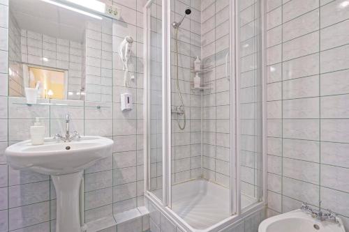 里加维科特里耶酒店的带淋浴和盥洗盆的白色浴室