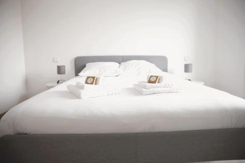 卢森堡Beautiful 2BR Apartment in Kirchberg的一张白色大床,配有白色床单和枕头