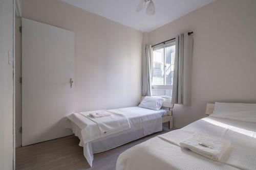 伊塔佩马Apto com churrasqueira privativa Itapema-SC CPE203的白色的客房设有两张床和窗户。