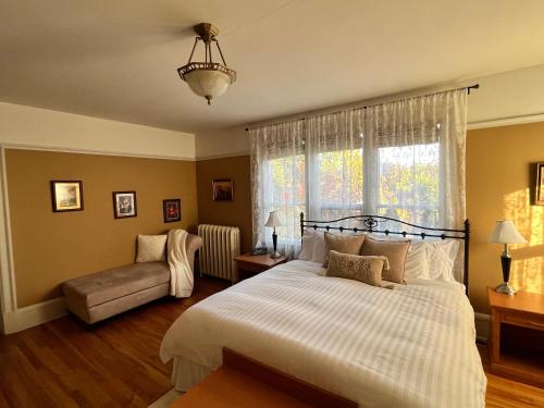 基洛纳Stirling House的一间卧室配有一张床、一张沙发和一个窗口