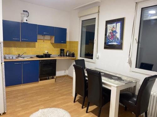 伍珀塔尔Shared Serenity accommodation的厨房配有蓝色橱柜和桌椅