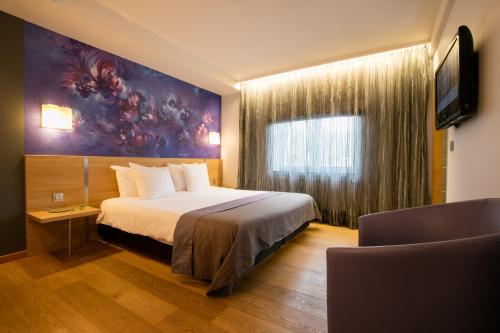 斯帕Hôtel-Restaurant L'Auberge的一间酒店客房,配有一张床和一台电视