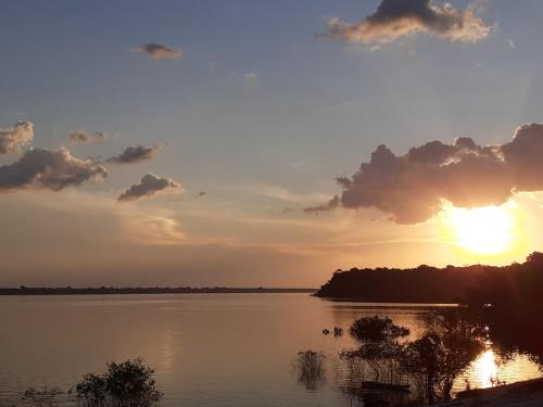 马瑙斯POUSADA CANTO DOS PASSÁROS的日落在湖上,阳光照耀