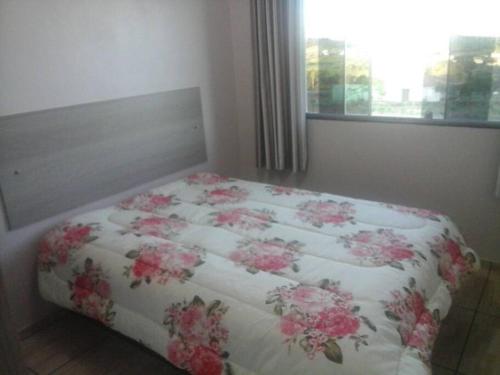 马沙蒂纽Cabana econômica com 2 quartos的一张床上的毯子,上面有粉红色的花朵