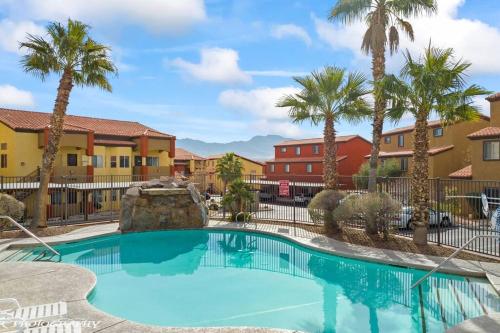 梅斯基特Mesquite Retreat 2 Bd Condo by Cool Properties LLC的棕榈树和建筑度假村的游泳池