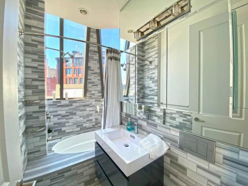 纽约Gorgeous Three Bedroom West Village Townhouse的一间带水槽和浴缸的浴室,并设有一个窗口