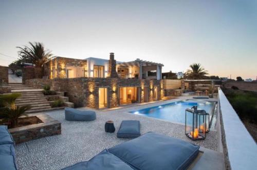伊奥斯乔拉Ambiente Luxury Suites的房屋前有游泳池的房子