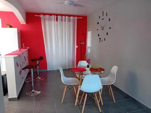 勒穆莱Studio La Félicité的厨房配有桌椅和红色墙壁