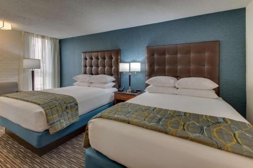 埃德蒙逊圣路易斯机场梨树酒店的两张位于酒店客房的床,拥有蓝色的墙壁