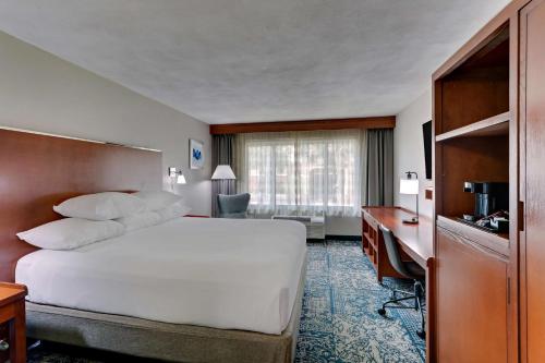 圣安东尼奥Drury Inn & Suites San Antonio Airport的酒店客房设有一张大床和一张书桌。