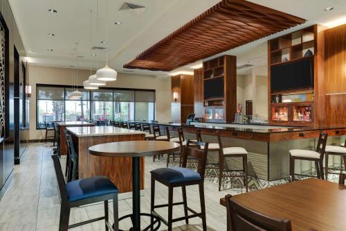 奥兰多Drury Plaza Hotel Orlando - Disney Springs Area的一间带桌椅的餐厅和一间酒吧