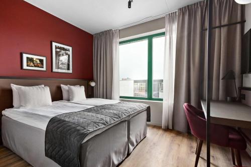 斯德哥尔摩Best Western Plus Hotel Kungens Kurva的一间卧室配有一张床、一张书桌和一个窗户。