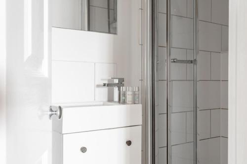莫尔登Maldon Executive Apartments的带淋浴的浴室和白色冰箱。