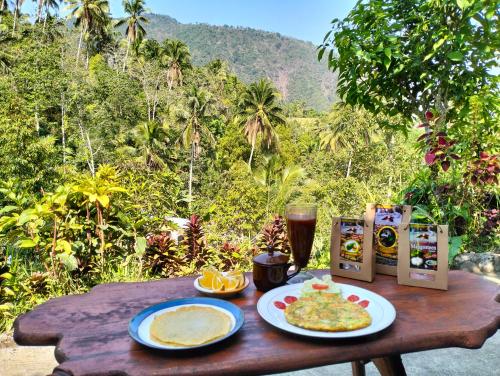 新加拉惹Ananda Homestay Lemukih的一张带食物和一杯啤酒的木桌