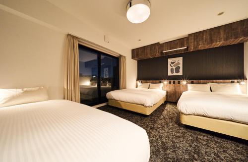 福冈Grand STAY 博多駅北的酒店客房设有两张床和窗户。
