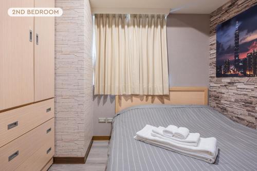 台北Comfy & Central 2B1b, Sleeps 5, 3min to Daan MRT 舒適市中心 2房1衛 睡5人 3分到大安站的一间卧室配有一张床,上面有两条毛巾